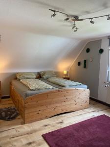 ein Schlafzimmer mit einem Holzbett in einem Zimmer in der Unterkunft FERIENHAUS ZUM BULLERJAN - Coozy Haus mit Kamin in EuÃŸerthal + 19 Fotos