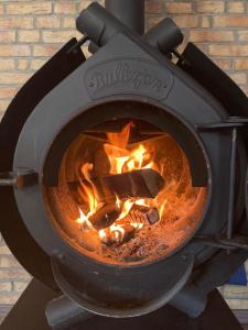 ein Feuer in einem Ofen mit Flammen darin in der Unterkunft FERIENHAUS ZUM BULLERJAN - Coozy Haus mit Kamin in EuÃŸerthal