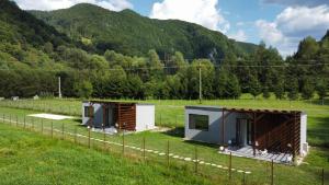 two tiny houses in a field with mountains in the background at Tiny Teo Sătic in Satic +10 photos