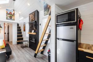 a tiny house with a refrigerator and a microwave at Hot Tub & BBQ Deck, Tiny Home Near Zion National Park in Apple Valley
