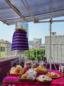 un tavolo con pane e altro cibo sopra di Mala Vecindad Beer Hotel a Città del Messico
