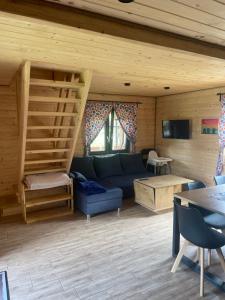 a living room with a blue couch and wooden walls at Domki Bingo i Blue in Werlas