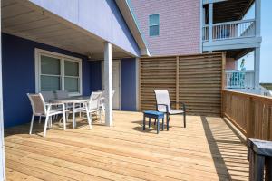 a patio with a table and chairs on a deck at Oceanfront Carolina Beach House - Dogs Allowed -Near Boardwalk in Carolina Beach