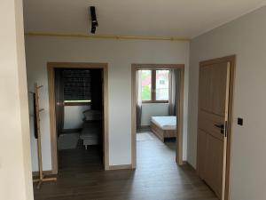 Habitación con pasillo, cama y ventana en Rybnicka 109A, en Skorka