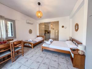a bedroom with two beds and a desk at Sea view Lefkes in Kithnos