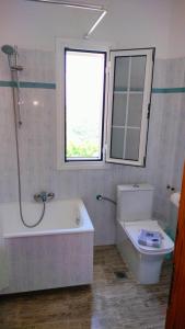a bathroom with a tub and a sink and a window at Studios Evgenia Parga in Parga +39 photos