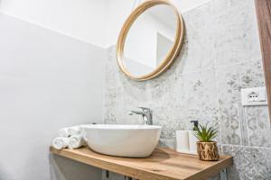 un bagno con un lavandino bianco e uno specchio di Carmelitani Loft Catania Center a Catania