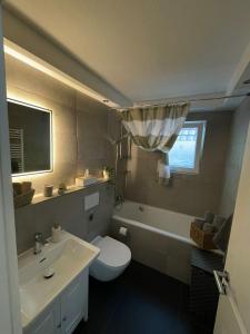 a bathroom with a white toilet and a sink at Ferienwohnung Elya, Ihre Auszeit zwischen Therme, Outlet, Natur in Bad Münstereifel +17 photos