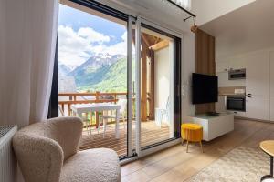 ein Wohnzimmer mit Blick auf einen Balkon in der Unterkunft Charmant appartement duplex, 6 personnes, 3 chambres, 2 salle de bains, dans Loudenvielle à 50m du skyvall in Loudenvielle