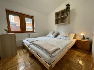 a bedroom with a large bed with pillows on it at Halász Vendégház Jakuzzival Tiszakécske in Tiszakécske