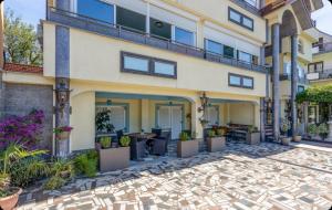 an apartment building with a patio with potted plants at Villa Ana Selce in Selce