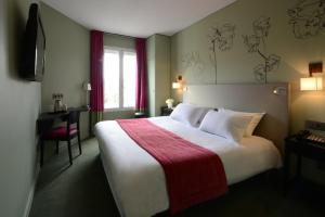 a hotel room with a large bed with a red blanket at Hôtel Orchidée in Paris