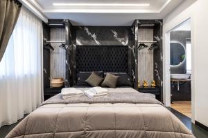 a bedroom with a large bed with a black headboard at La Dimora Cuore & Passione in Naples