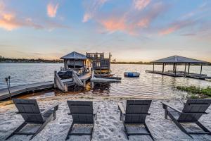 a dock with chairs and a house on the water at 5Br Sleeps 16 Private Pool-Dog Friendly-Fire Pit in Lake Placid
