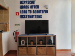 a television on a stand in a living room at Burgau Ocean View Apartment in Burgau