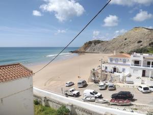 a view of a beach with cars parked in a parking lot at Burgau Ocean View Apartment in Burgau