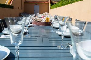 ein Tisch mit Gläsern und Tellern und einem Kuchen darauf in der Unterkunft Casa grande con piscina en el centro de Calella, Tramuntana in Calella