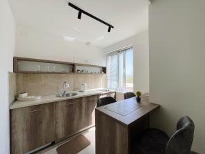 a kitchen with a sink and a wooden table at Guest House Koliqi - Hotel & Apartments in Ulcinj +274 photos