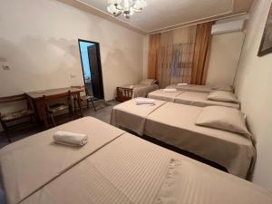 a hotel room with three beds and a table at Vila Bella in Durrës