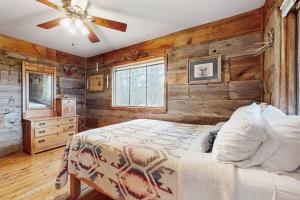 a bedroom with a bed and a wooden wall at Bigfoot Lodge in Angel Fire