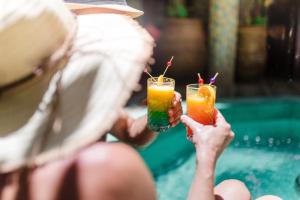 a woman holding two drinks in their hands at Abelia Riad - 2025 Guest Choice Award in Marrakesh
