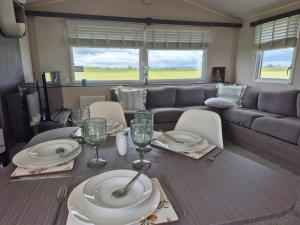 a living room with a table and a couch at Whitstable 3 Bedroom Home in Seasalter