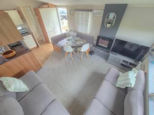 a living room with a gray couch and a table at Whitstable 3 Bedroom Home in Seasalter
