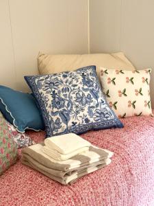 a pile of towels and pillows on a bed at Modern apartment with balcony in the center of Svolvær in Svolvær