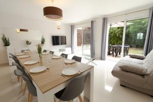 a living room with a dining table and a couch at Villa Cosy avec Jardin Paris Disney in Bry-sur-Marne