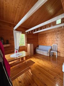 une chambre dans une cabane en rondins avec un lit et une table dans l'établissement Traditional Finnish lakeside off-grid cabin, à Joensuu