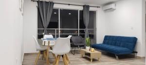 a living room with a blue couch and a table and chairs at Brisa de la Bahia in Cartagena de Indias