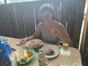 a woman sitting at a table with a plate of food at Ayahuasca y Turismo in Tamshiyacu