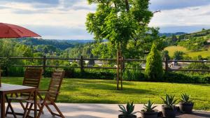 a table and chairs with a view of a garden at À mi-chemin in Marcillac-Vallon