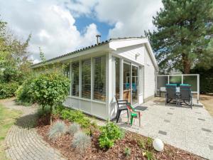 ein kleines Haus mit Wintergarten und Terrasse in der Unterkunft Family Home by the Dunes in Sint Maartensvlotbrug