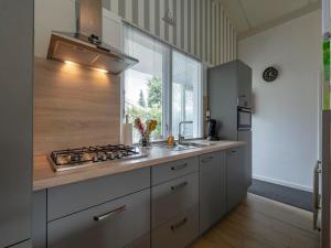 eine Küche mit einer Spüle, einem Herd und einem Fenster in der Unterkunft Family Home by the Dunes in Sint Maartensvlotbrug + 11 Fotos