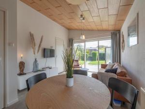 a living room with a table and chairs and a couch at Bungalow in Callantsoog near Sandy Beach in Callantsoog