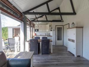 a kitchen and living room with a table and chairs at Bungalow near Sint Maartenszee Beach in Sint Maartensvlotbrug +11 photos