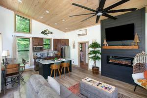 a living room with a ceiling fan and a fireplace at Smoky Mountain Dove | Hot Tub, Firepit, Fireplace in Sevierville