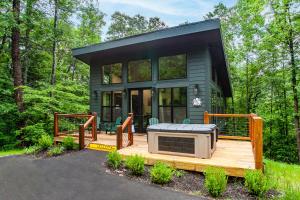 a tiny house with a hot tub on a deck at Smoky Mountain Dove | Hot Tub, Firepit, Fireplace in Sevierville