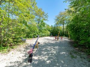 a park with a playground with a swing at Holiday Home Sint Maartenszee near Beach in Sint Maartenszee