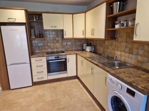 a kitchen with a white refrigerator and a dishwasher at Westport luxury apartment Knockranny in Westport