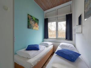 two beds in a room with a window at Holiday Home Sint Maartenszee near Beach in Sint Maartenszee