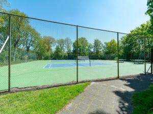a chain link fence around a tennis court at Holiday Home Sint Maartenszee near Beach in Sint Maartenszee