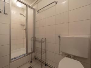 a bathroom with a toilet and a shower and a tub at Holiday Home Sint Maartenszee near Beach in Sint Maartenszee +13 photos