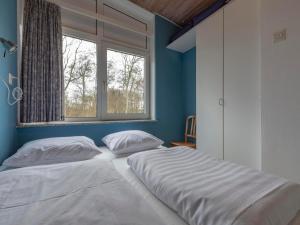 two beds in a bedroom with a window at Holiday Home Sint Maartenszee near Beach in Sint Maartenszee