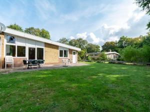 a house with a patio and a yard at Holiday Home Sint Maartenszee near Beach in Sint Maartenszee