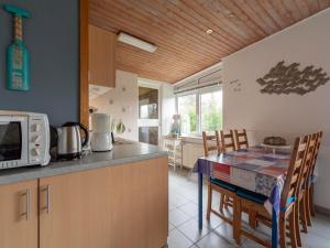 a kitchen with a table with chairs and a microwave at Holiday Home Sint Maartenszee near Beach in Sint Maartenszee