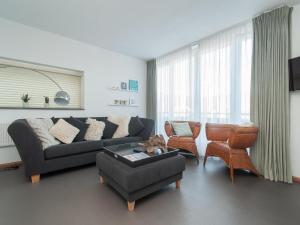 a living room with a couch and chairs at Suite Duinzicht in Callanstoog village square in Callantsoog