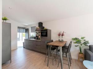 a kitchen and dining room with a table and chairs at De Blenck 29 Bungalow near dunes, beach in Callantsoog
