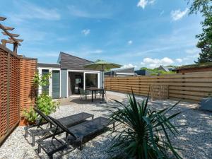 a patio with a table and an umbrella at De Blenck 29 Bungalow near dunes, beach in Callantsoog